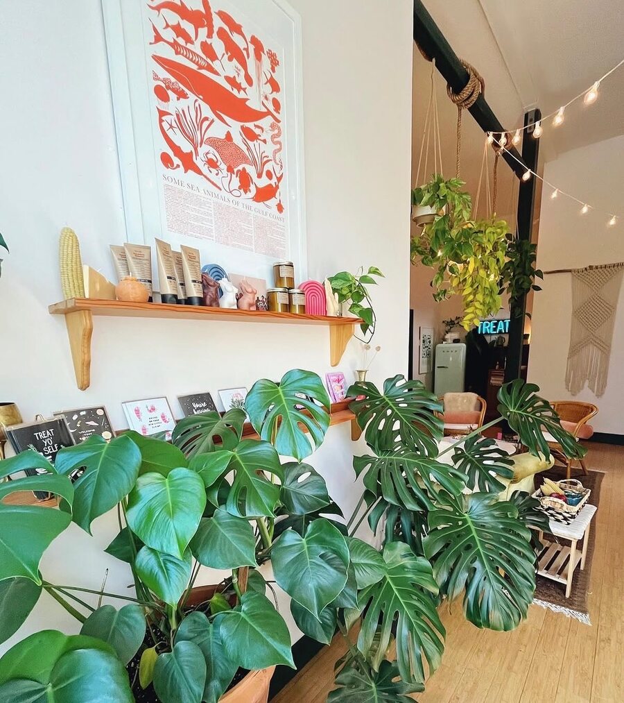 Treat salon — floral painting detail with brass lamp and plants