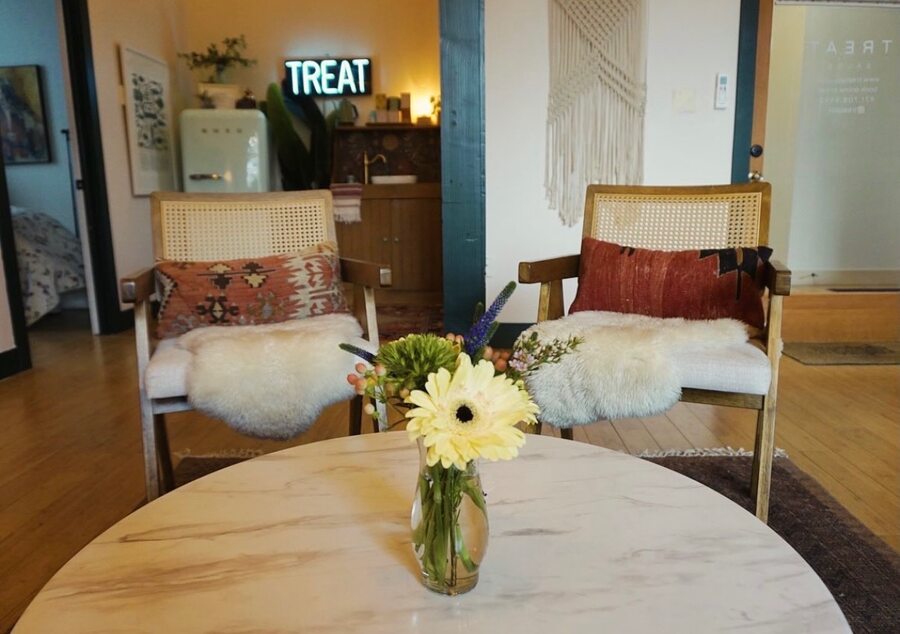 Treat salon — tattooed arms, earthy tote bag, plants